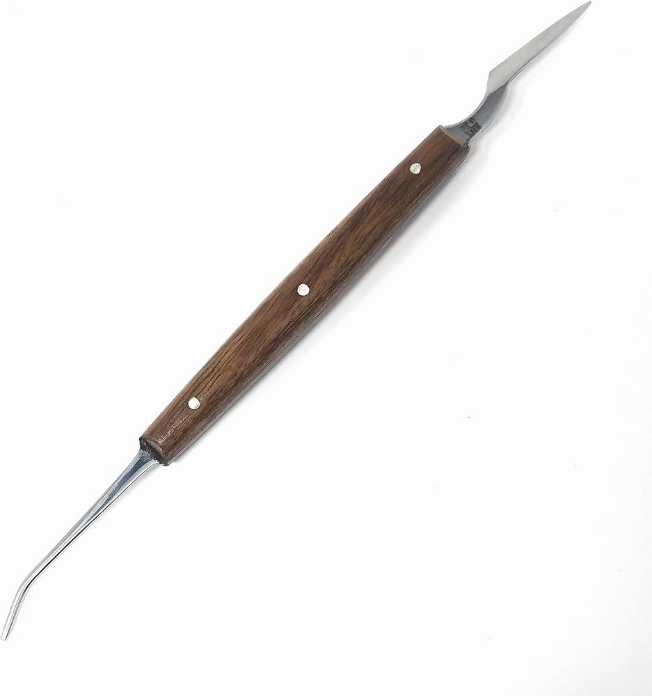 A metal dental tool with a wooden handle.