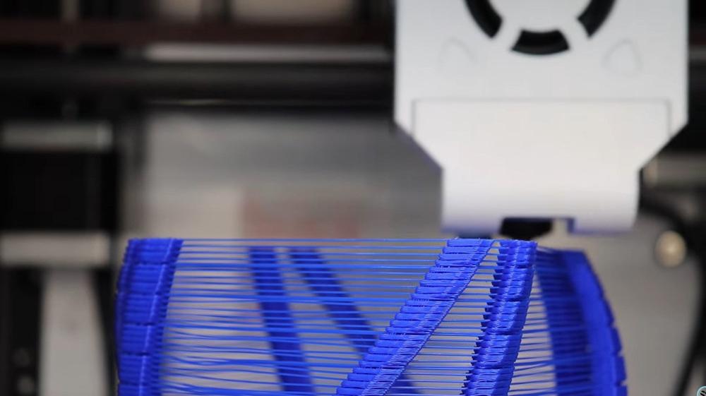 A 3D printer is printing a blue and round object.