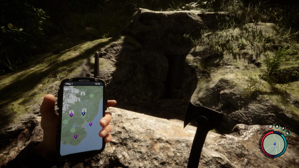 A hand holding a phone with a map app open in front of a cave entrance.