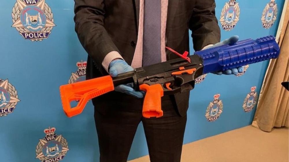 A police officer is holding a 3D printed firearm.