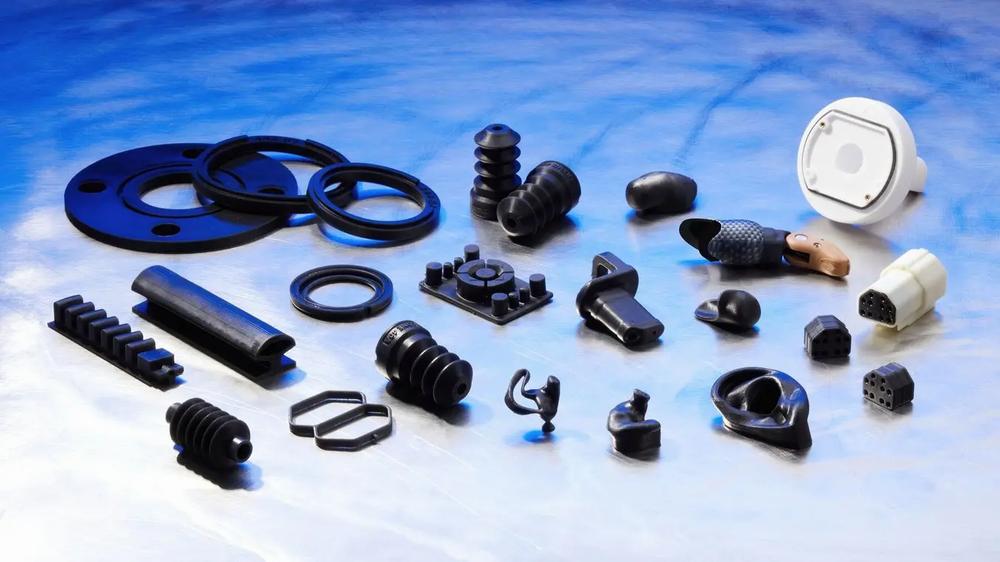 Various black rubber products are displayed on a shiny metal surface.