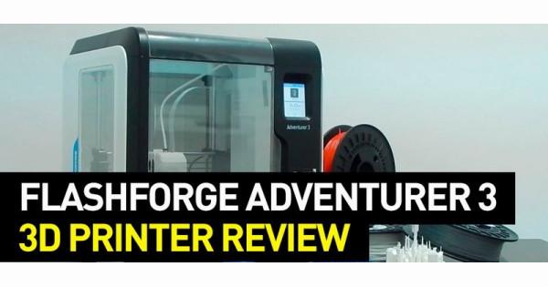 A Flashforge Adventurer 3 3D printer sits on a table with a spool of filament next to it.