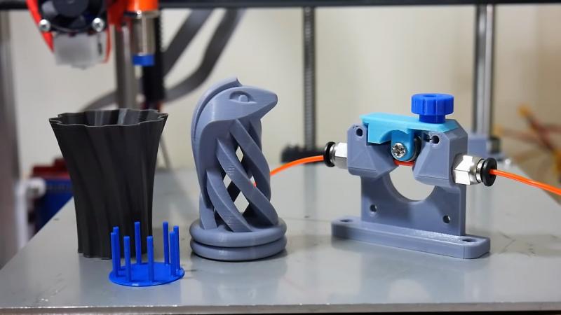 A 3D printed chess piece (knight) sits next to the printers extruder.