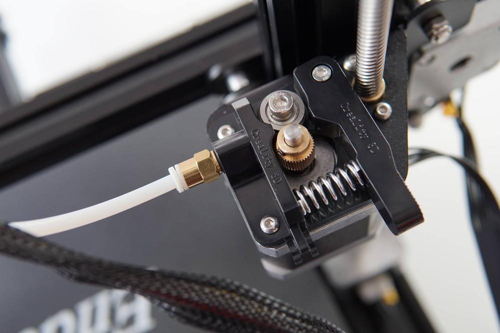 A close up of a Bowden tube connected to the extruder of a 3D printer.