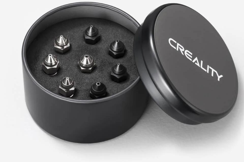 A set of six Creality brand metal nozzles in a round black case.