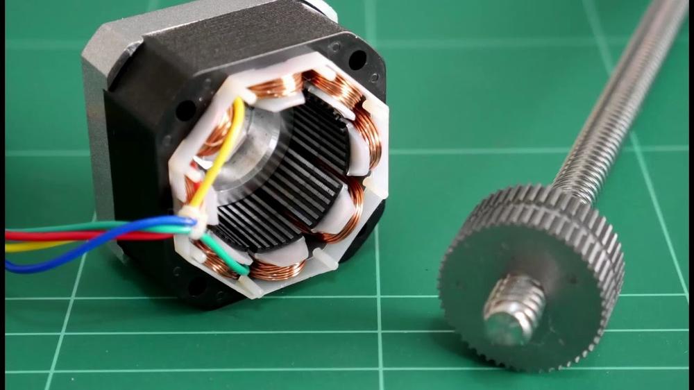 A stepper motor and a lead screw, which are parts of a 3D printer.