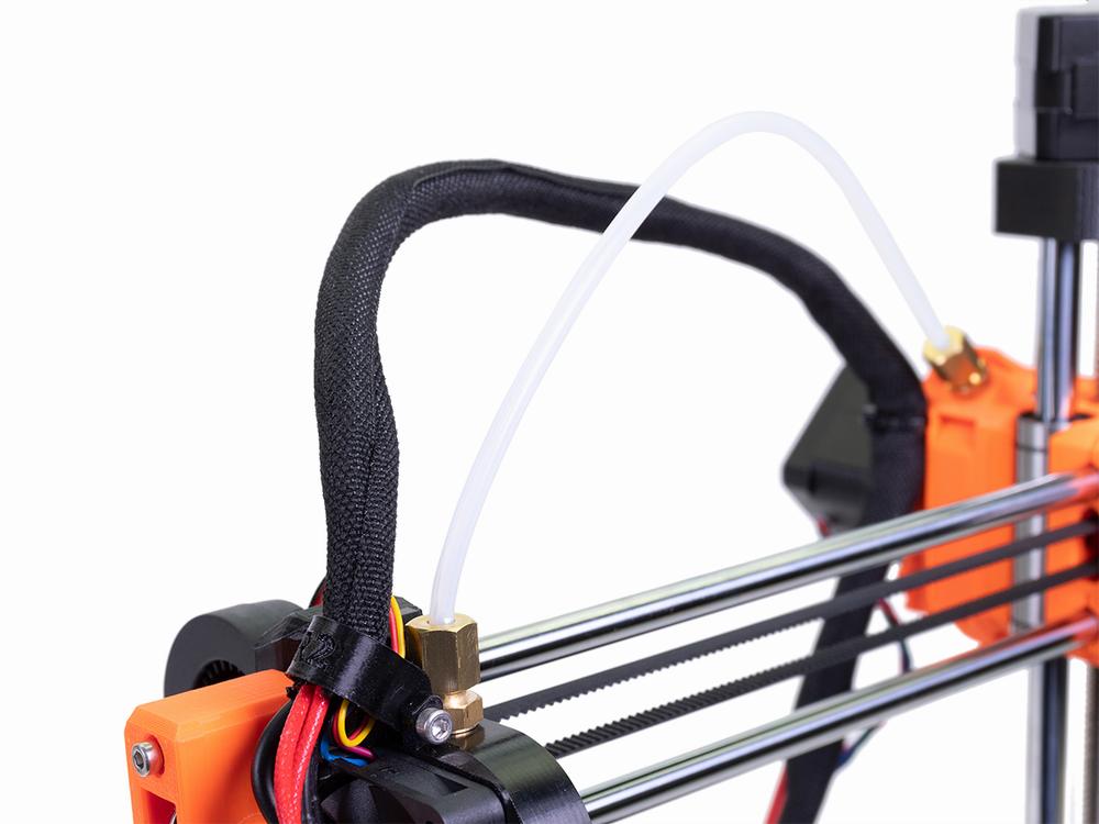 A close-up of a Bowden tube connected to a 3D printers extruder.