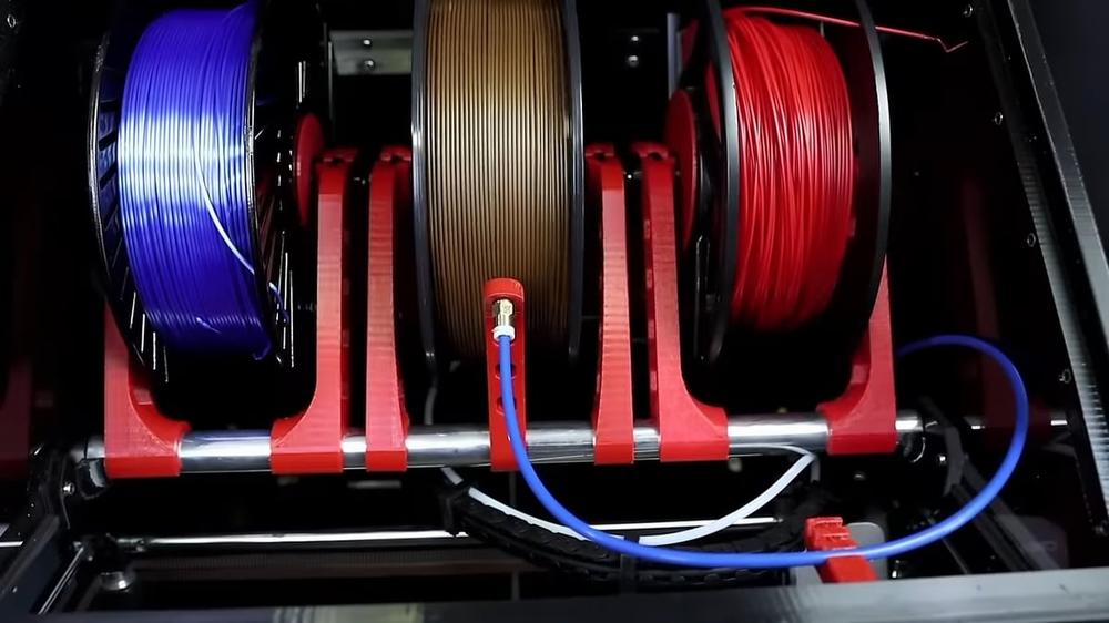 Four spools of 3D printer filament on a rotating spool holder.