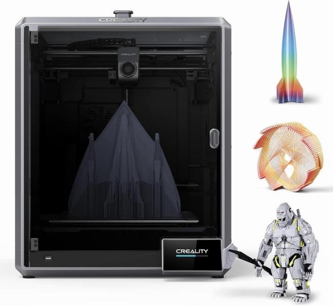 The image shows a black and gray Creality 3D printer with a blue light on the inside and a nearly finished 3D print of a building on the print bed, with a rainbow rocket ship, a colorful spiral, and a gray figurine of a person in armor standing next to it.