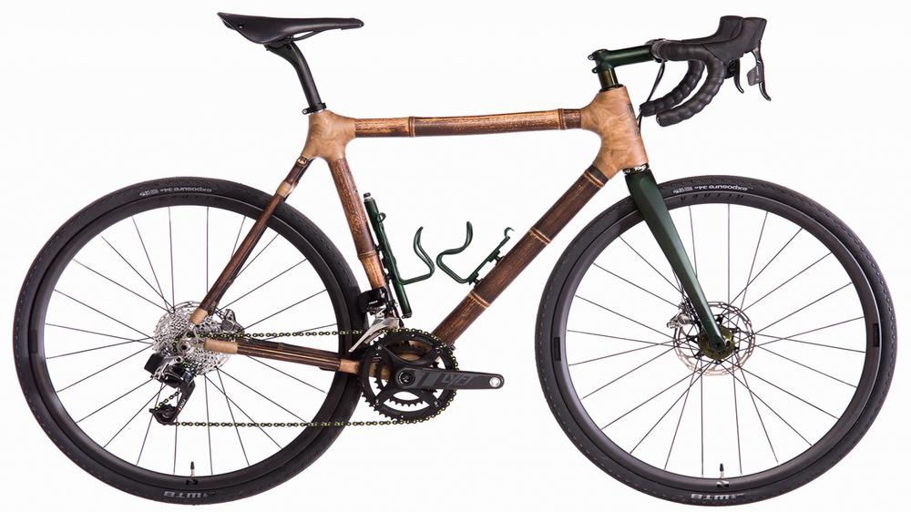 An image of a bicycle made of bamboo with a black seat, black handlebars, and dark green wheels.