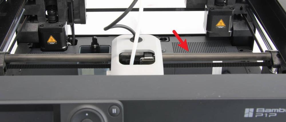 There is a red arrow pointing at a white connector on the right side of the printer.