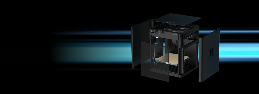 An illustration of an open black 3D printer with a blue light shining through it.