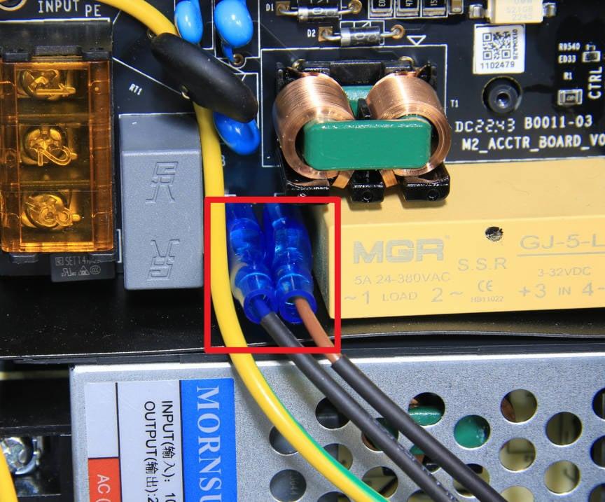 A close-up of a circuit board with a red box around a blue and yellow wire.