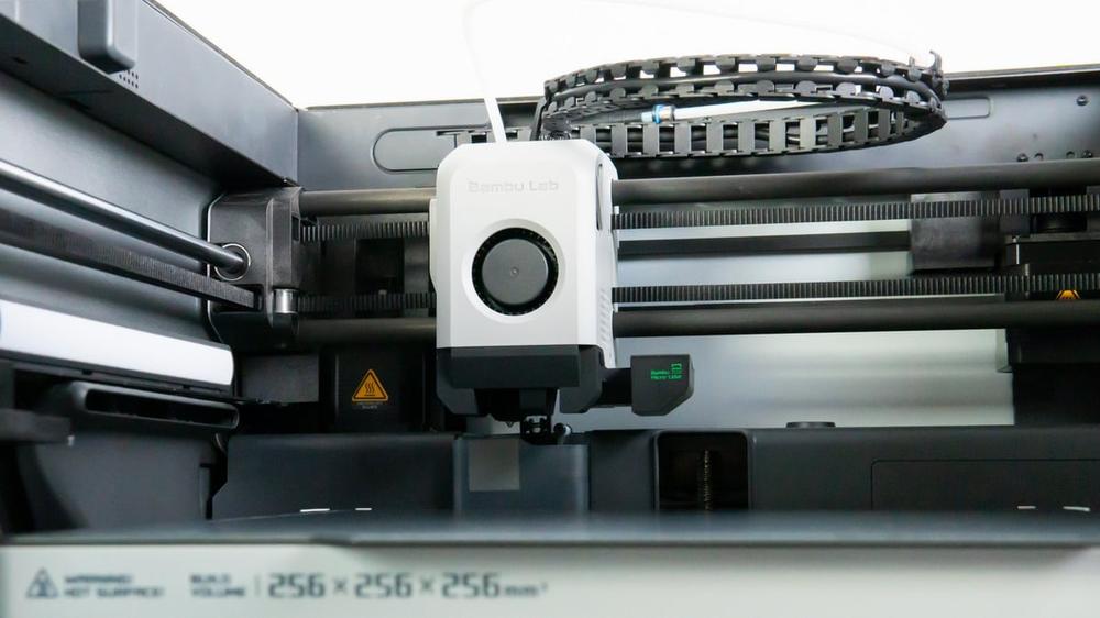 A 3D printer prints a white object.