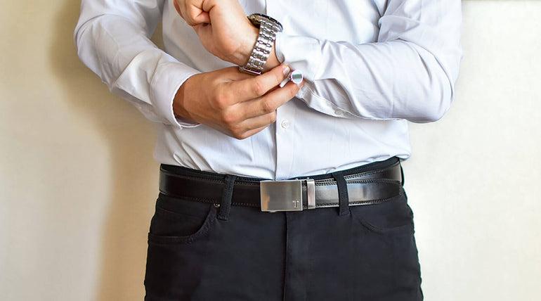 A man fastens the cufflink on his left sleeve.