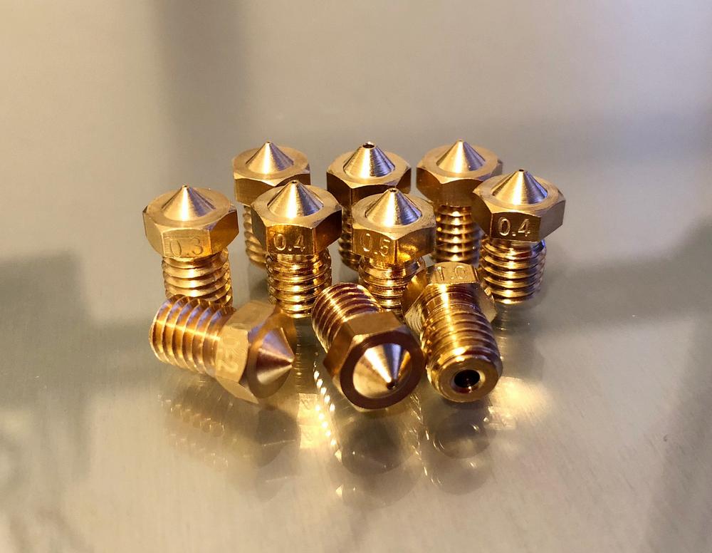 A group of ten brass nozzles for 3D printers.