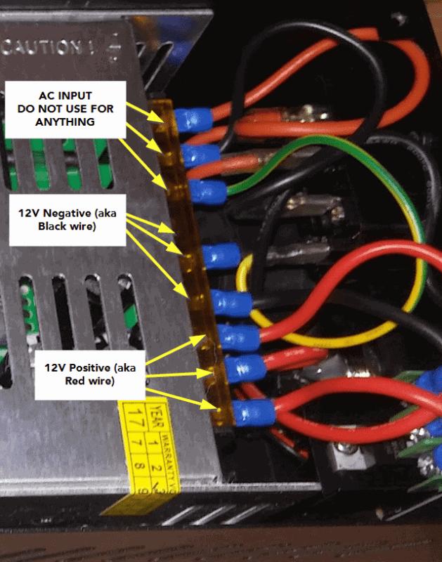 A view of an electrical panel with labels indicating the positive and negative terminals for 12V connections.