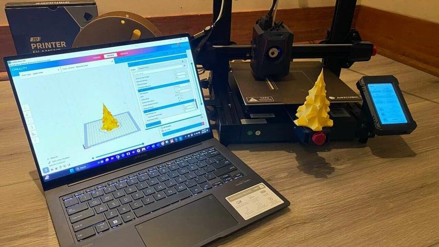 A 3D printer is printing a yellow Christmas tree.