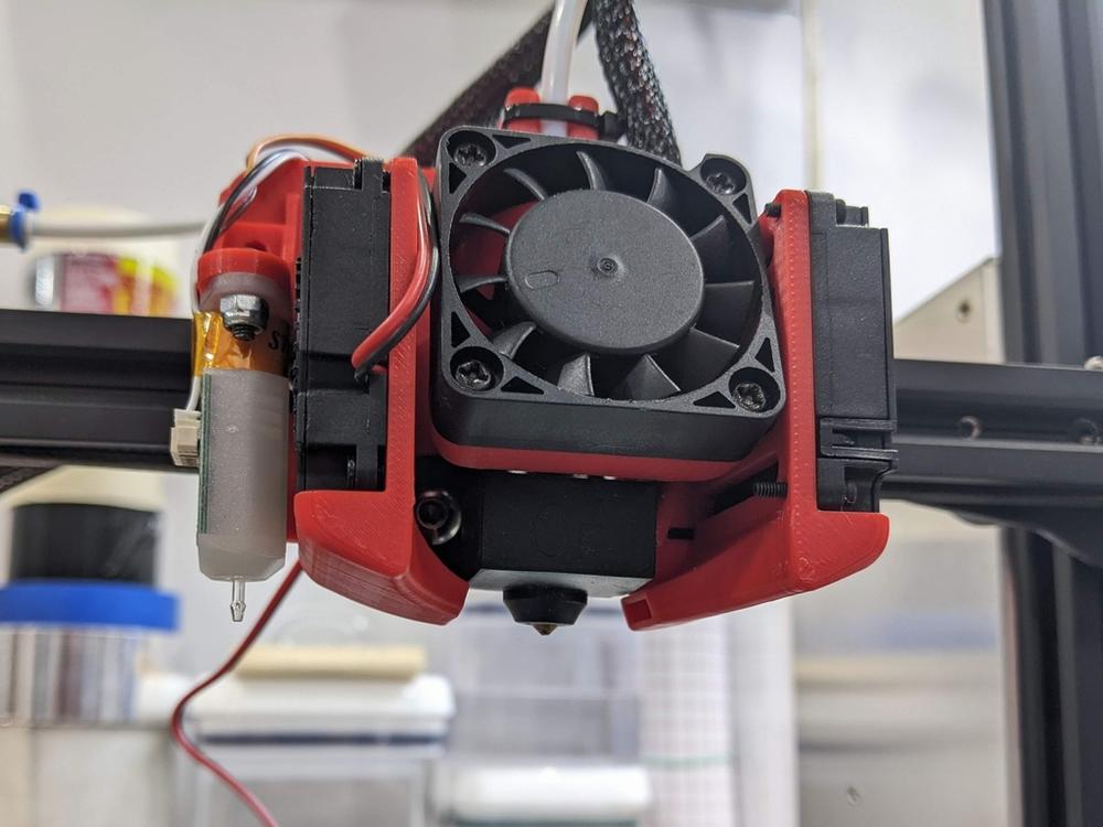 A close-up of a 3D printers hot end, which is the part that melts the filament and extrudes it onto the build platform.
