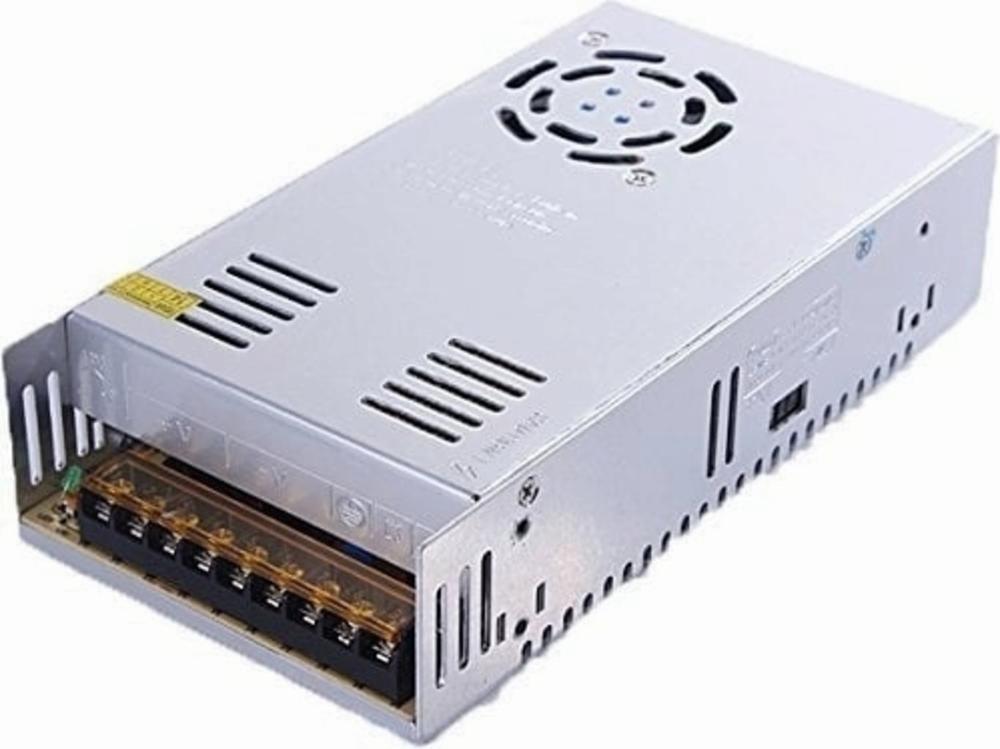 A silver power supply with a black fan on top and a row of connection ports on the front.