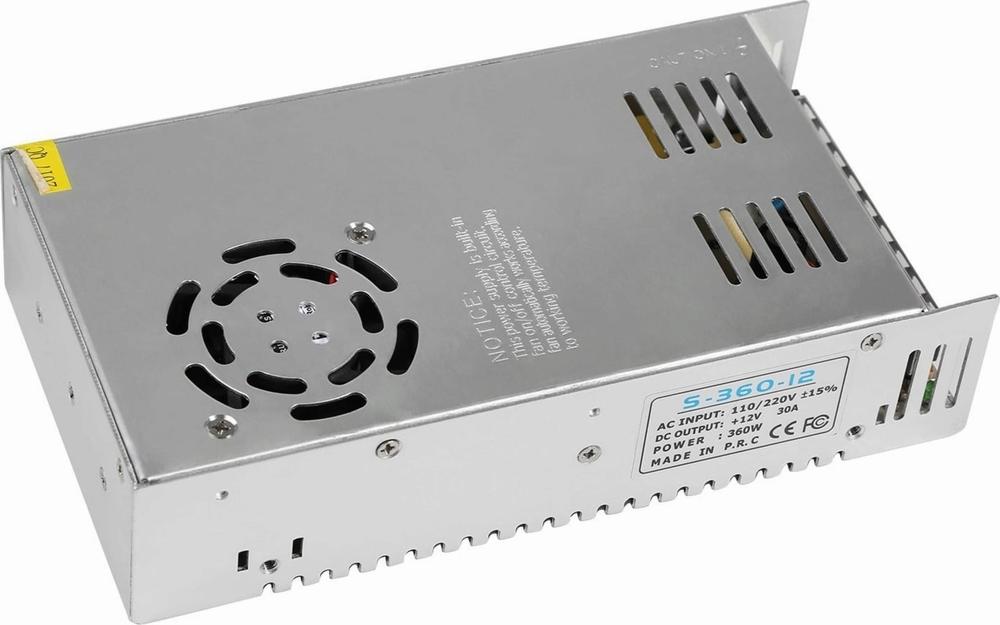 A silver metal power supply with a black fan on top and black text printed on a white label on the side.