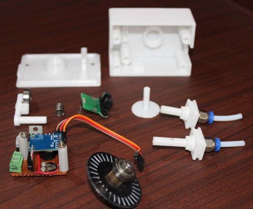 The image shows various parts of a 3D printer, including the housing, circuit board, and other components.