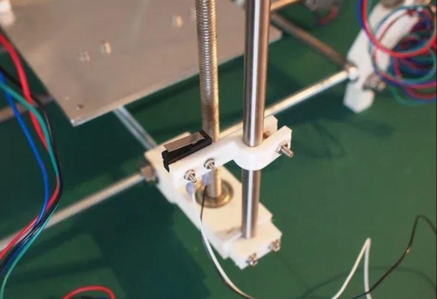 A close-up of a 3D printers Z-axis endstop switch, mounted to the Z-axis lead screw.