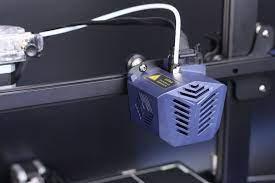 A 3D printer with a blue cooling fan attached to the side.