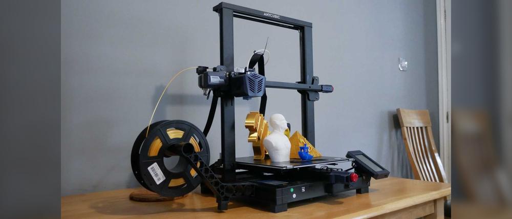 An image of an Artillery Hornet 3D printer printing a golden 3D model of a head.